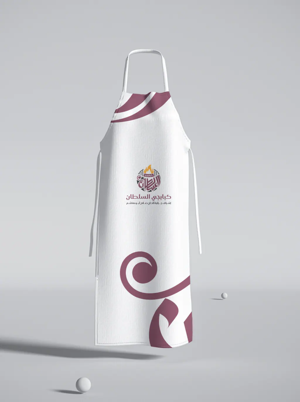 Kababgy Al-Sultan white chef apron with the maroon curl