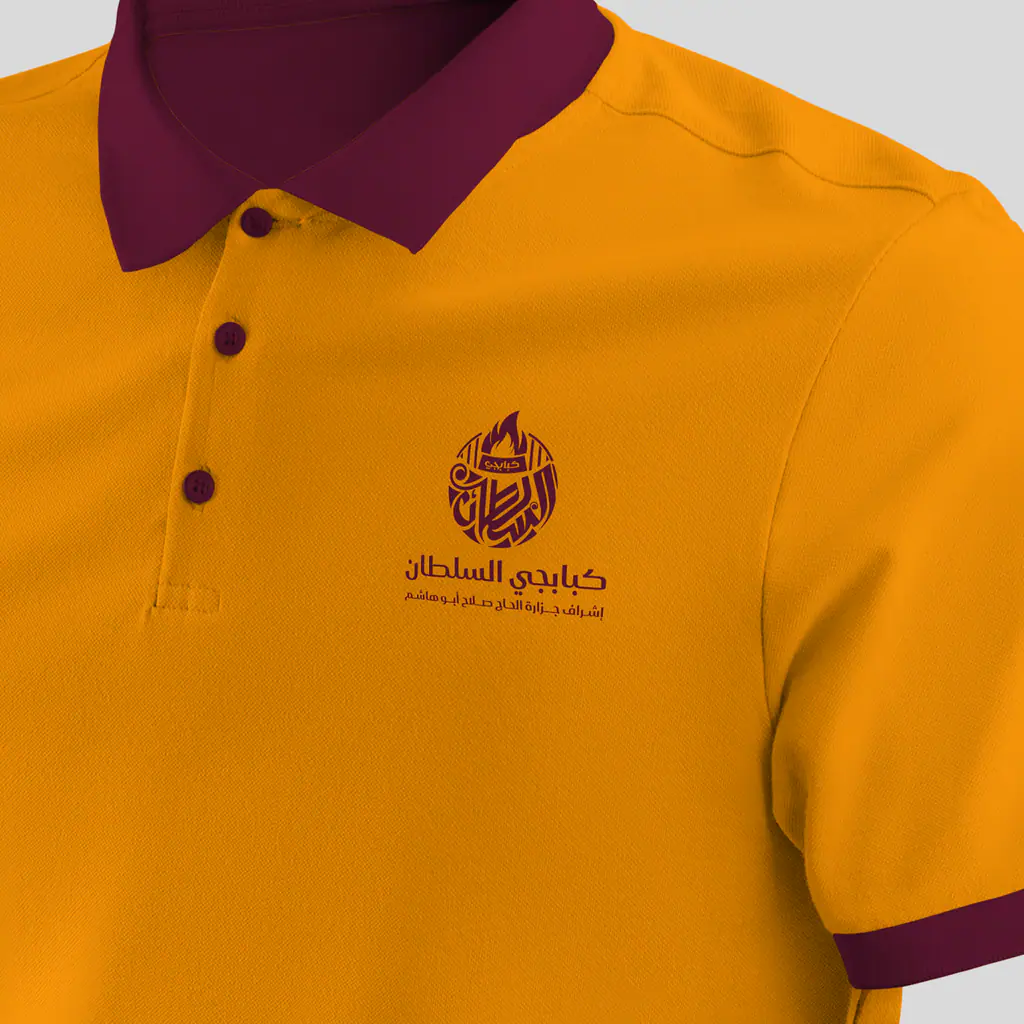 Kababgy Al-Sultan logo embroidered on an orange polo