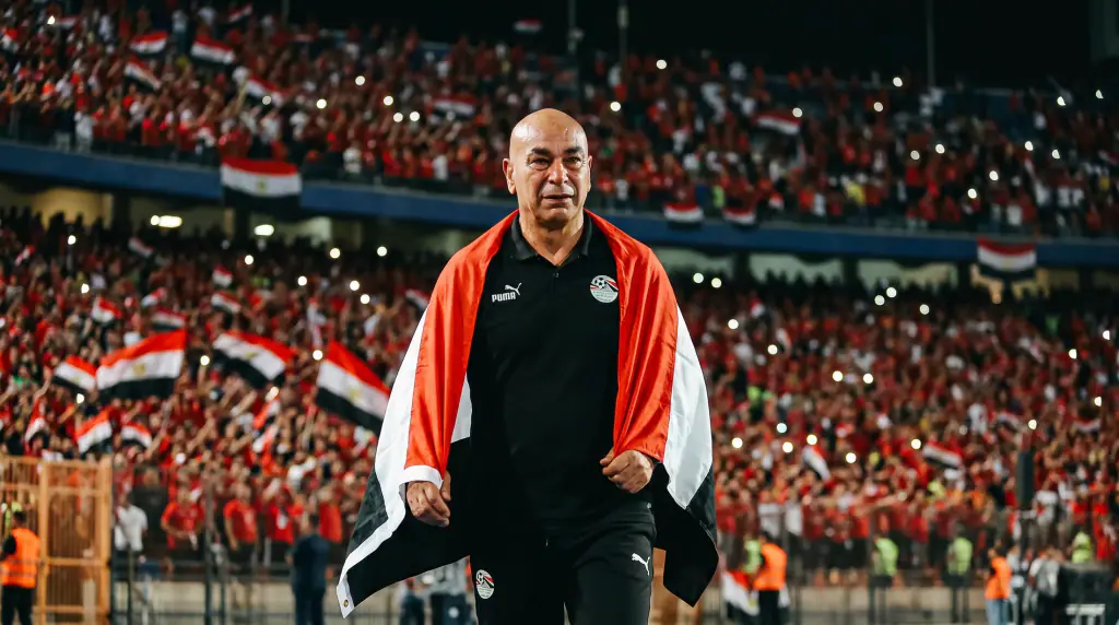 The coach walking with Egypt's flag on his shoulders