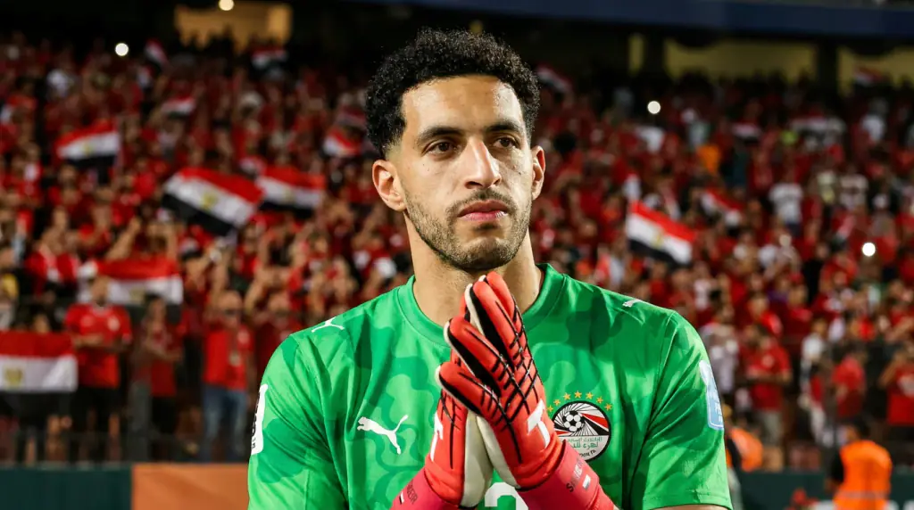 The goalkeeper in green, hands together